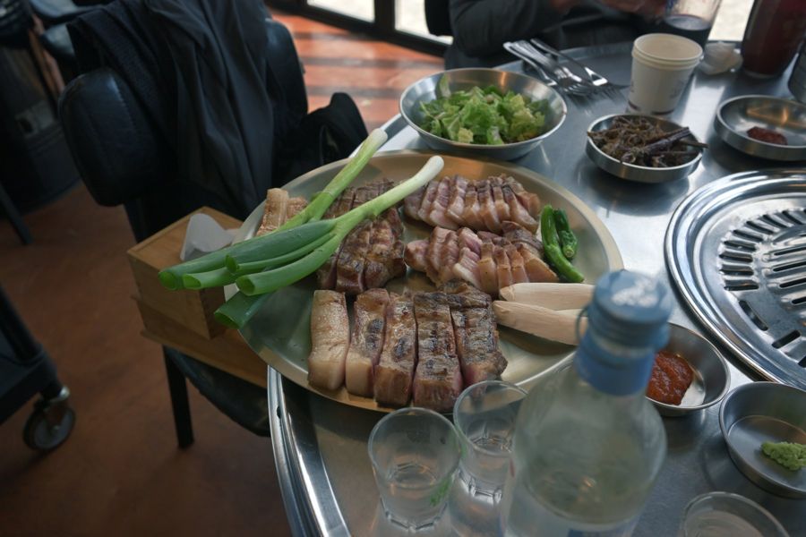 Мясо и зелень на решётке корейского барбекю.