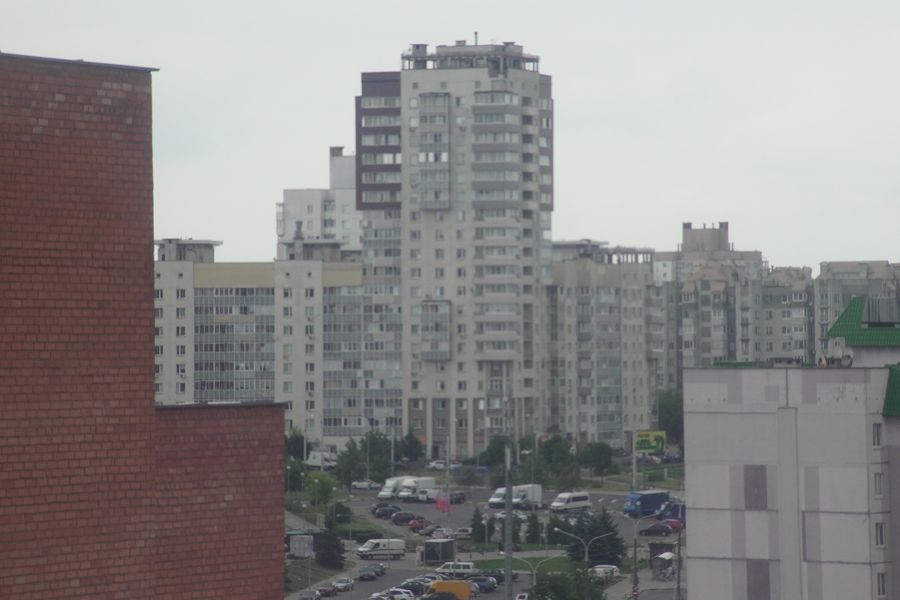 Высотный дом над соседними крышами и двором.