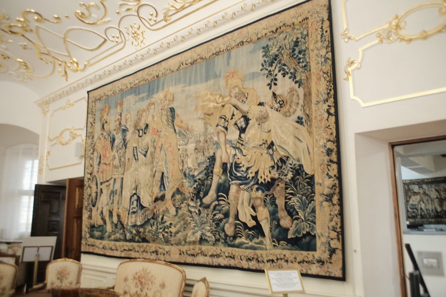 Большой гобелен на светлой стене зала.