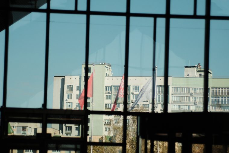 Город через оконную решётку: прямоугольники фасадов и неба. Минск.